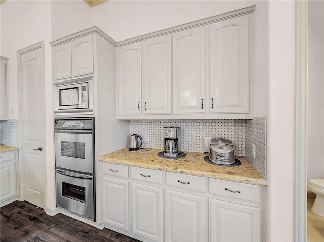 kitchen with decorative backsplash, appliances with stainless steel finishes, and white cabinets