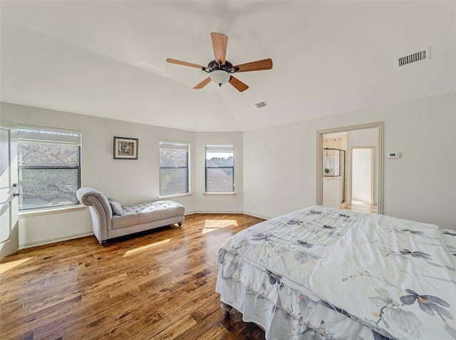 bedroom featuring visible vents, ceiling fan, baseboards, and wood finished floors