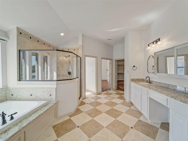 full bathroom with vanity, visible vents, a shower stall, a spacious closet, and a garden tub