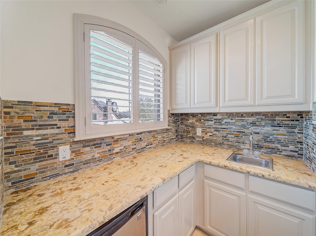 kitchen with a sink, tasteful backsplash, and white cabinets