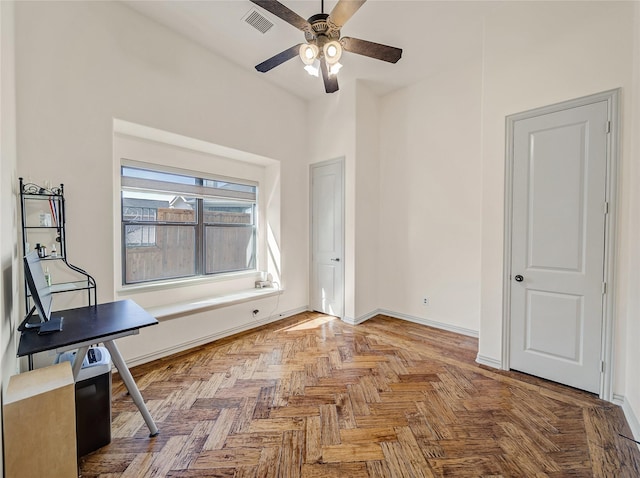 unfurnished office with visible vents, a ceiling fan, and baseboards