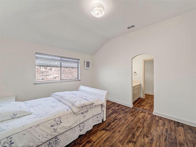 bedroom featuring visible vents, baseboards, lofted ceiling, arched walkways, and dark wood-style flooring