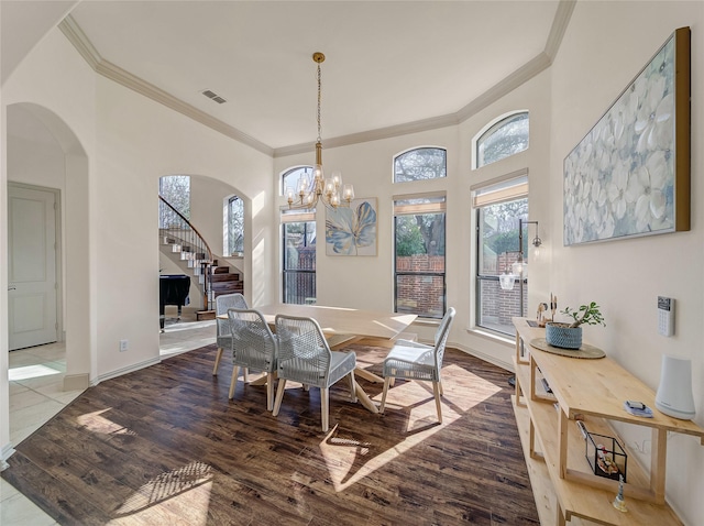 dining room with ornamental molding, stairs, and wood finished floors