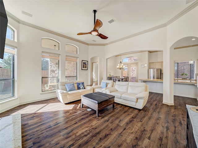 living room with visible vents, arched walkways, dark wood-type flooring, and plenty of natural light