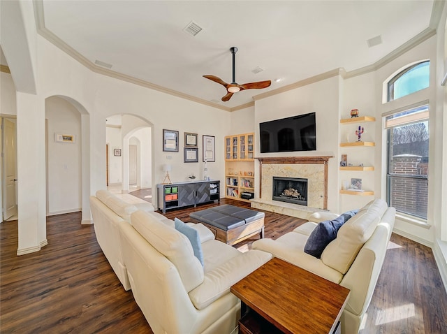 living room featuring dark wood-style floors, visible vents, a high end fireplace, and ceiling fan