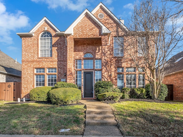 traditional-style home featuring brick siding and a front lawn