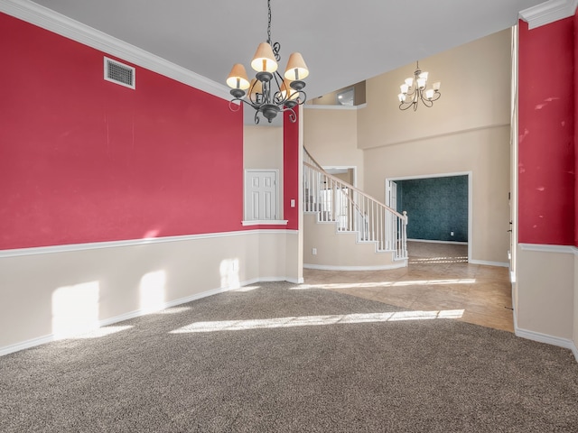 spare room with stairs, a notable chandelier, carpet, and visible vents