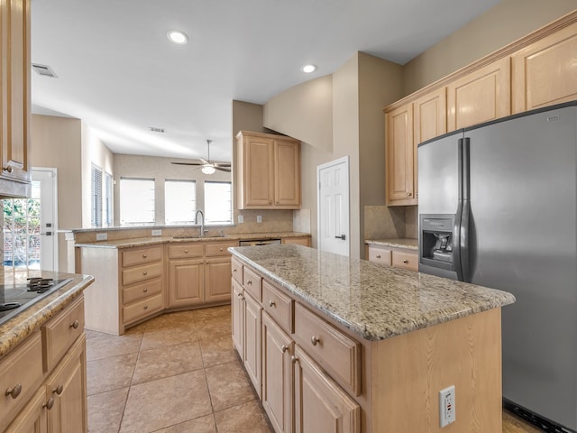 kitchen featuring a sink, stainless steel fridge, and light brown cabinetry