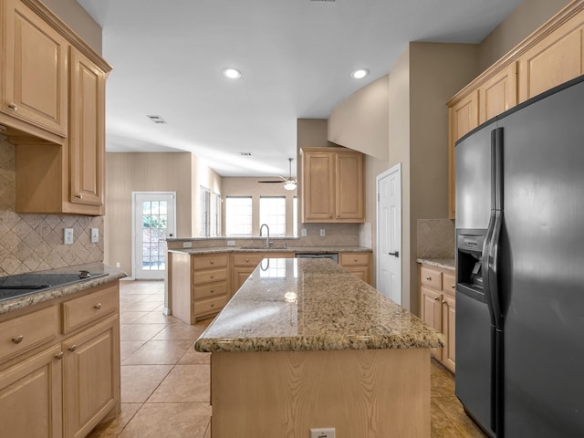 kitchen featuring black electric stovetop, light brown cabinetry, fridge with ice dispenser, a peninsula, and a sink