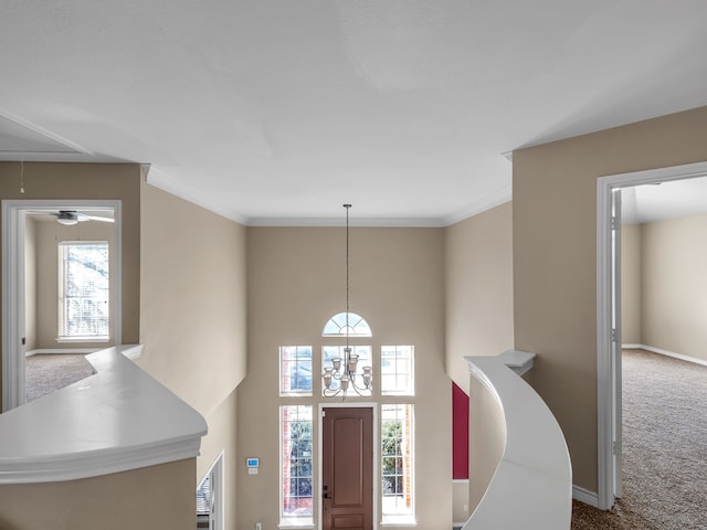 foyer entrance with baseboards, carpet floors, a healthy amount of sunlight, and ornamental molding