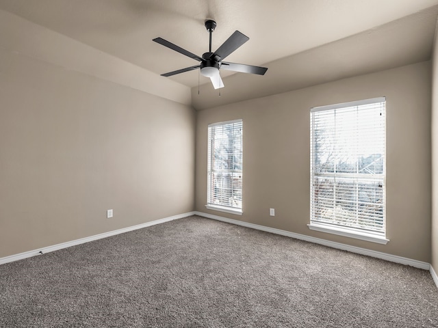 empty room with lofted ceiling, carpet flooring, baseboards, and ceiling fan