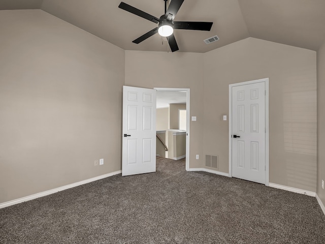 unfurnished bedroom with dark colored carpet, visible vents, and vaulted ceiling