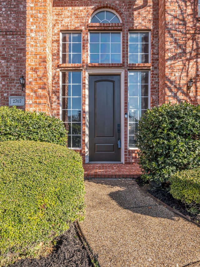 property entrance featuring brick siding