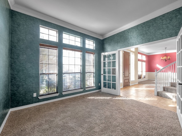 carpeted spare room featuring a chandelier, baseboards, ornamental molding, and stairway