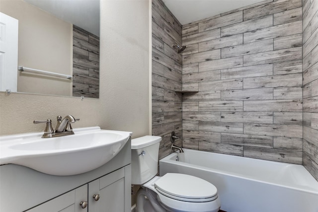 bathroom with a textured wall, toilet, vanity, and shower / tub combination