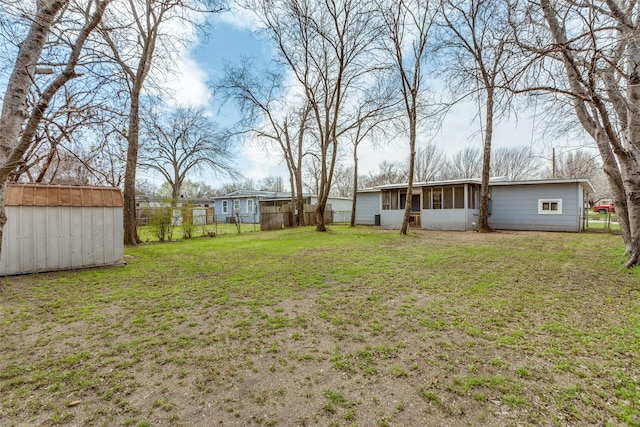 view of yard featuring an outdoor structure, a storage unit, and fence