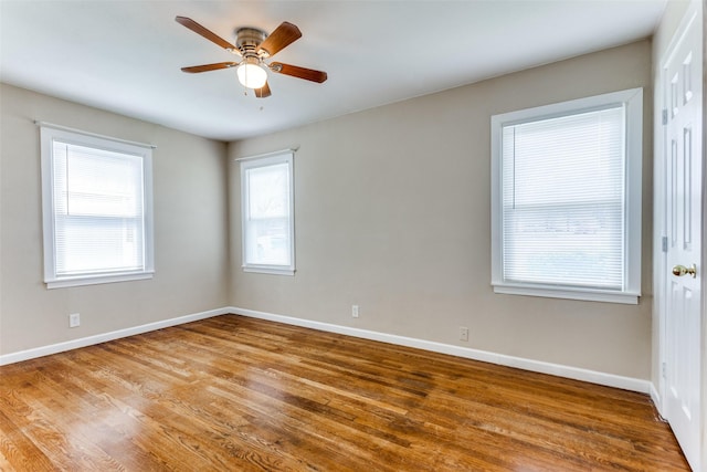 unfurnished room featuring baseboards, wood finished floors, and a ceiling fan