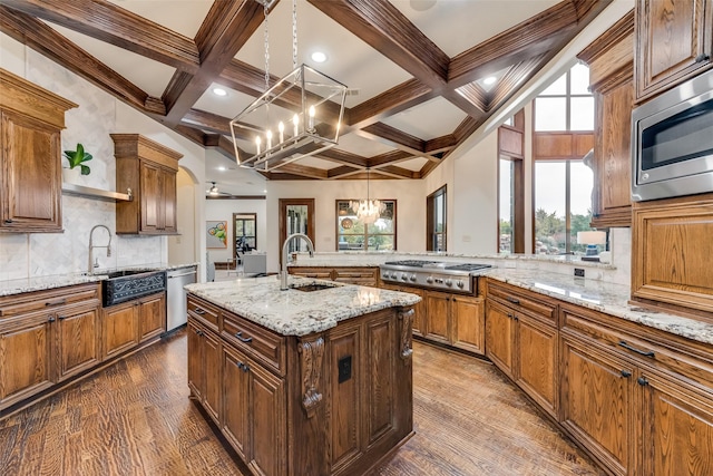 kitchen featuring a sink, a notable chandelier, coffered ceiling, and stainless steel appliances