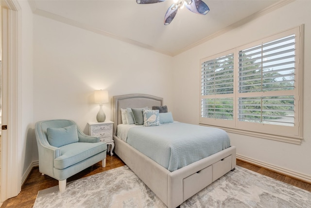 bedroom featuring ceiling fan, baseboards, wood finished floors, and ornamental molding