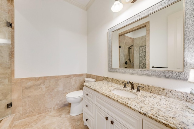 bathroom featuring toilet, a stall shower, ornamental molding, tile walls, and vanity