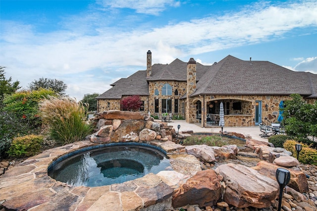 view of swimming pool featuring an in ground hot tub and a patio area