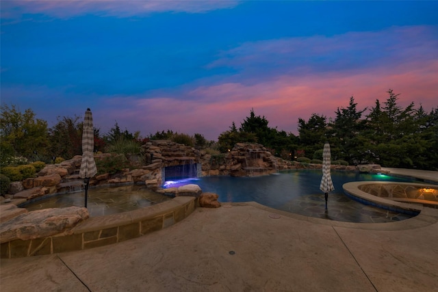 outdoor pool with a patio area and an in ground hot tub