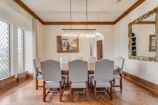 dining area featuring baseboards, arched walkways, and crown molding