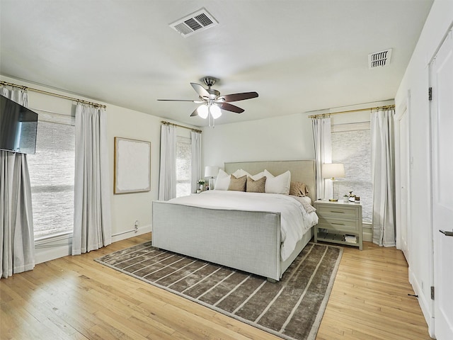 bedroom featuring visible vents, light wood finished floors, and ceiling fan