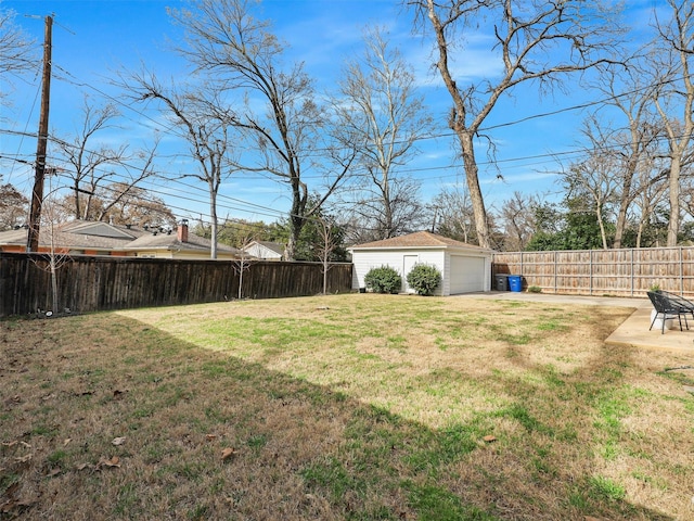 view of yard with an outbuilding, a fenced backyard, a patio, and a garage