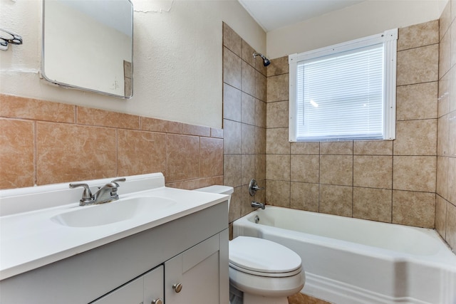 full bathroom featuring vanity, toilet, tile walls, and bathing tub / shower combination