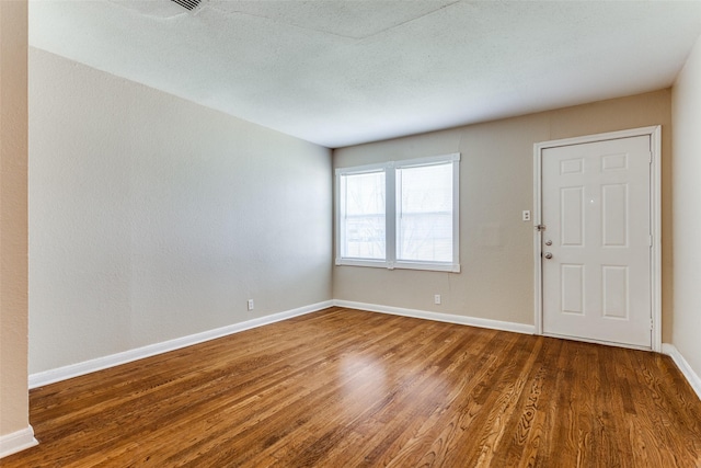 unfurnished room featuring baseboards and wood finished floors