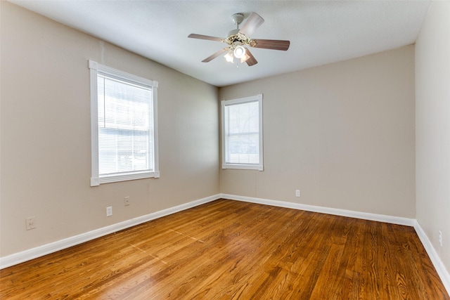 spare room with ceiling fan, baseboards, and wood finished floors