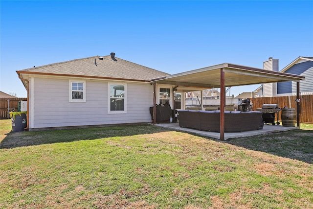 rear view of house featuring a fenced backyard, a yard, a shingled roof, an outdoor hangout area, and a patio area