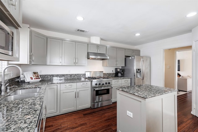 kitchen with visible vents, gray cabinets, under cabinet range hood, a sink, and stainless steel appliances