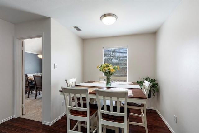 dining area featuring visible vents, baseboards, and wood finished floors