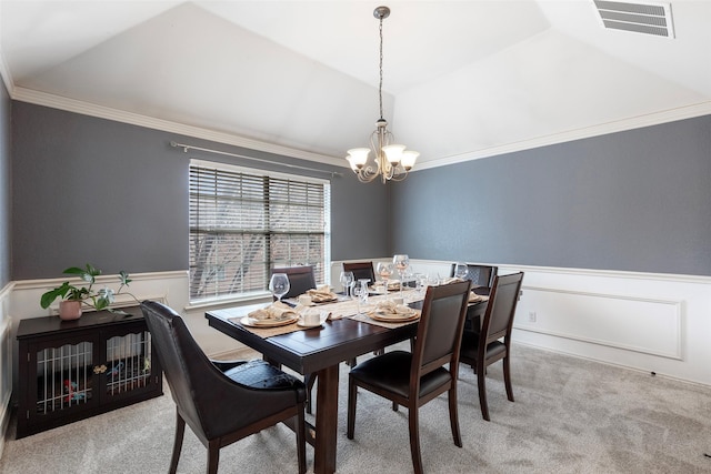 carpeted dining space featuring a notable chandelier, visible vents, wainscoting, and lofted ceiling