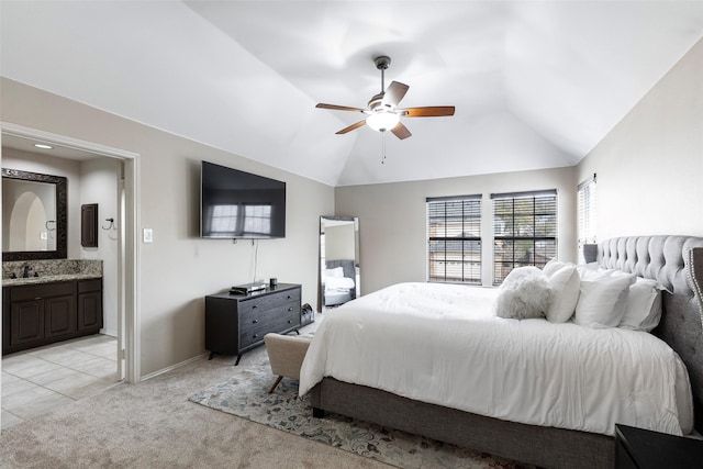 bedroom featuring connected bathroom, baseboards, light colored carpet, lofted ceiling, and a ceiling fan