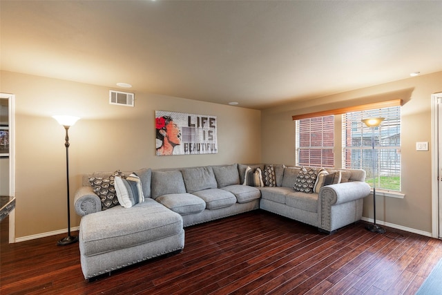 living room with visible vents, baseboards, and wood finished floors