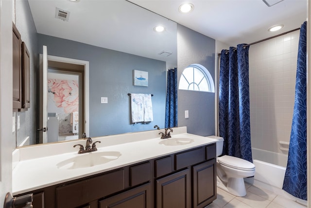 bathroom featuring double vanity, toilet, visible vents, and a sink