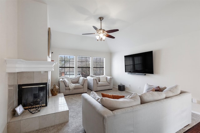 carpeted living area with baseboards, ceiling fan, a fireplace, and vaulted ceiling