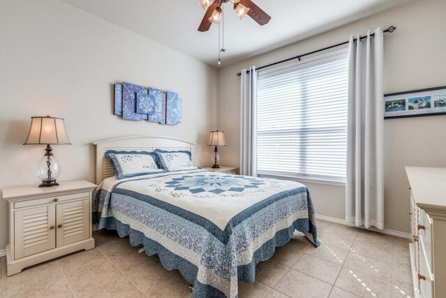 bedroom featuring light tile patterned floors, a ceiling fan, and baseboards