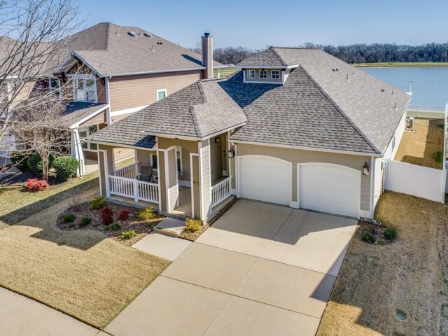 view of front of house featuring driveway, a porch, fence, roof with shingles, and a garage