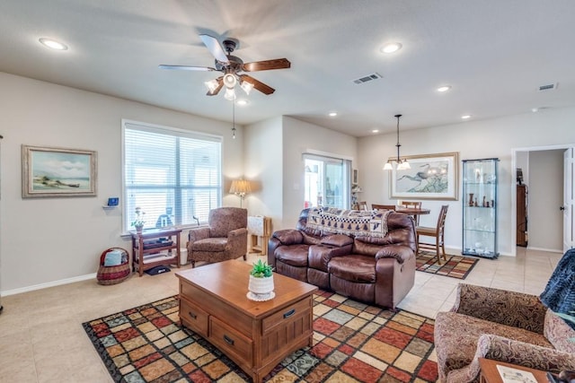 living room with visible vents, ceiling fan with notable chandelier, recessed lighting, light tile patterned flooring, and baseboards