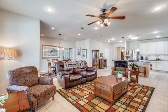 living room featuring light tile patterned floors, visible vents, recessed lighting, arched walkways, and ceiling fan