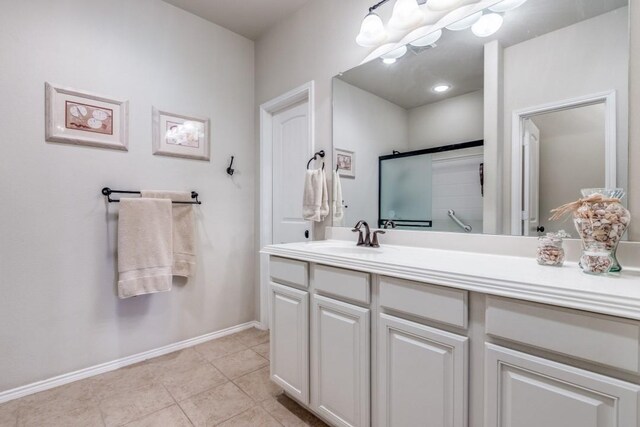 bathroom with tile patterned floors, an enclosed shower, an inviting chandelier, baseboards, and vanity