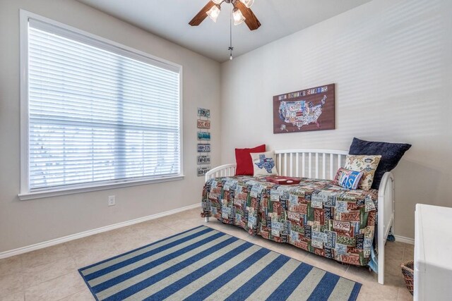 tiled bedroom featuring ceiling fan and baseboards