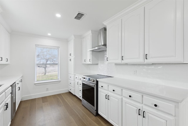 kitchen featuring visible vents, wall chimney range hood, white cabinets, stainless steel appliances, and dark wood-style flooring