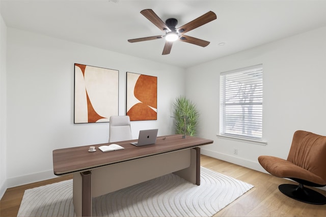 office with baseboards, light wood-type flooring, and ceiling fan