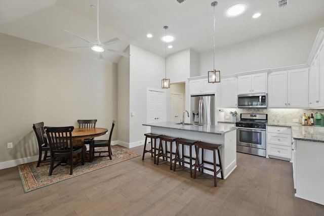 kitchen featuring white cabinets, dark wood-style floors, tasteful backsplash, and stainless steel appliances