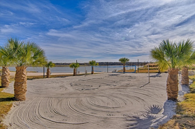 view of community with volleyball court and a water view